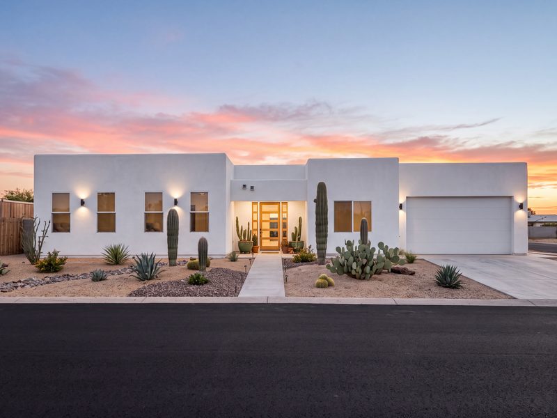White stucco single-story Arizona home with desert landscaping at sunset, built by Typhoon Builders