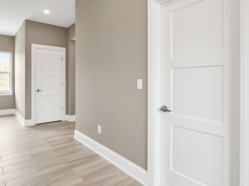 White shaker interior doors with casing and tall baseboards in a hallway